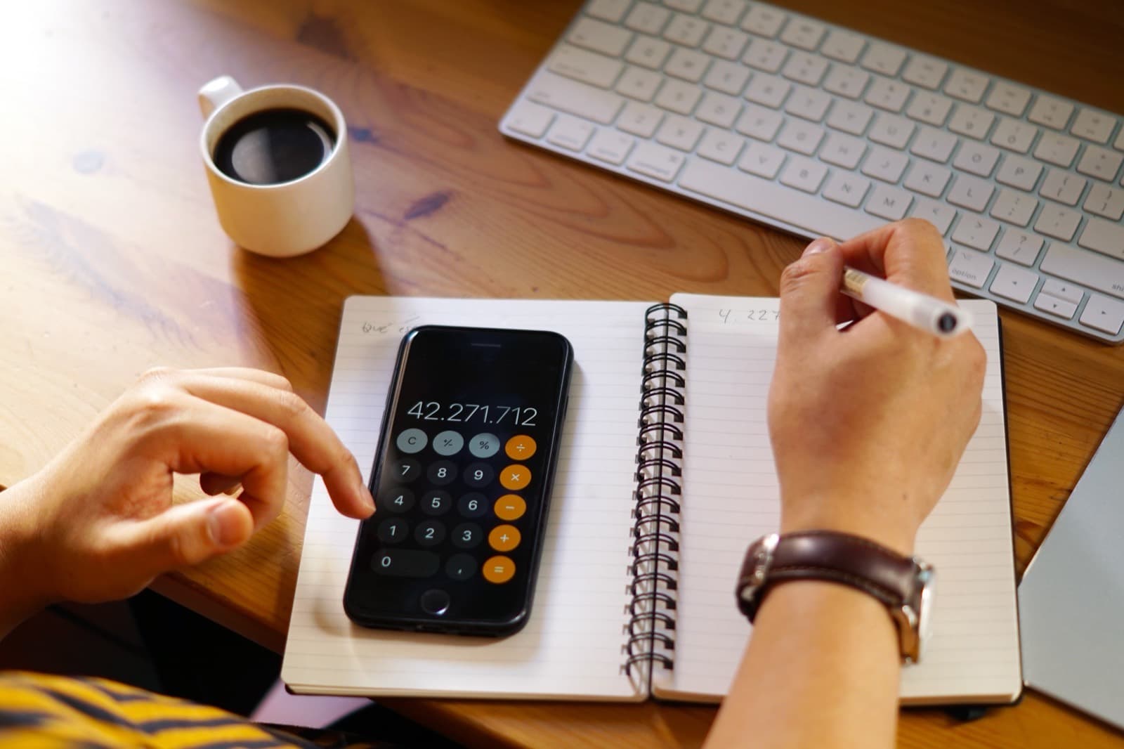 Person reviewing personal finances and calculations at a desk